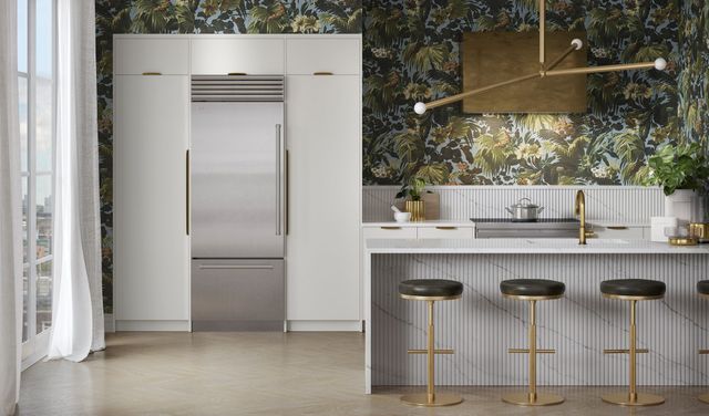 Front view of a modern kitchen with a stainless steel Sub-Zero bottom freezer refrigerator.